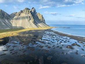 Aerial view of Mt. Vestrahorn, black lava beach, reflections on the water, Stokksnes, east of Höfn,