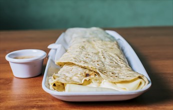 Close up of a Nicaraguan quesillo served on wooden table. Top view of Nicaraguan Quesillo on a