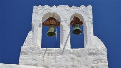 White bell tower with two bells in front of a bright blue sky, Chora, Old Town, Patmos, Dodecanese,