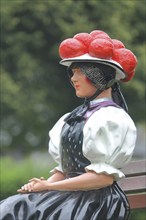 Doll in woman's traditional costume with Bollenhut on bench, Black Forest, Bollenhut, clothing,