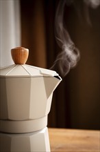 Geyser coffee maker, beige, close-up, boiling, steam from the spout, morning, breakfast, no people