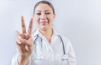 Female doctor counting number TWO isolated. Young female doctor counting number 2 on isolated