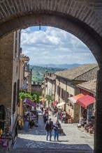 Archway and street with people in the medieval Gradara Castle, Marche, Italy, Europe