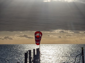 Windsock at sunrise over the sea in the Strait of Magellan, Punta Arenas, Chile, South America