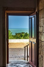 Old wooden door open inside the church overlooking the sea in the city of Olinda in Pernambuco,