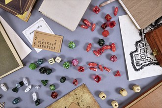 Tabletop roleplaying flat lay with RPG and game dices, rule book, notes and treasure map on gray