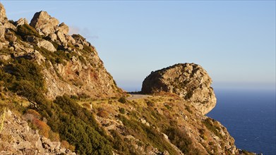 A rocky coastal landscape in the evening light with a clear sky and calm sea, Mani Peninsula,