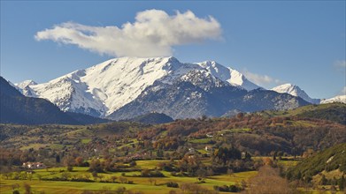 Idyllic landscape with snow-capped mountains, bright autumn colours and a single cloud, Erymanthos