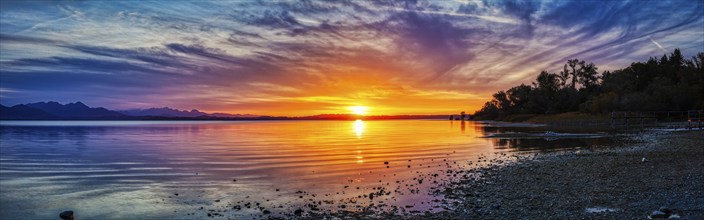 Dramatic panorama of a lake at sunset with intense colours and clouds, Chiemsee