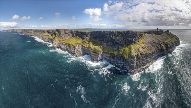 Imposing coastal cliffs with powerful sea waves under a blue sky, Cliffs of Moher