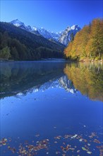 Mountains reflected in lake, fog, morning light, autumn colours, Riessersee, Waxensteine behind,