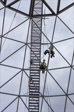 Two labourers working on a tall steel scaffold, Belfast