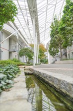 Inner courtyard with glass roof and narrow watercourse, surrounded by greenery, Kirchheim Teck,