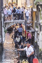 Venetian gondola with gondolier travelling on the canals, Overtourism, Venice, Venice, Italy,