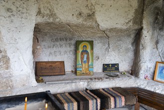 Niche in a cave with religious icons and candles, Bulgarian Orthodox cave monastery, rock