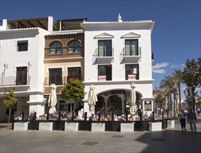 People sitting outside cafe at popular holiday resort town of Nerja, Malaga province, Spain, Europe