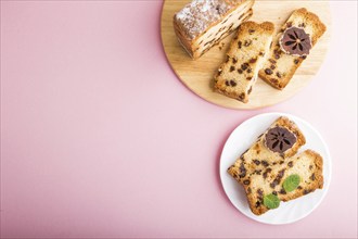 Homemade cake with raisins and dried persimmon on a pink pastel background. Top view, flat lay,