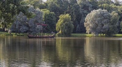 A large wooden boat with tourists floats on the lake. Belarus