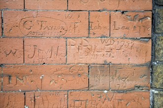 Eighteenth century graffiti scratched on brick wall of school building, Dedham, Essex, England, UK