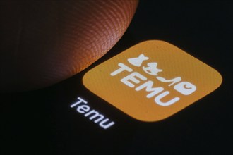 The logo of the Temu app (online marketplace) from Chinese company PDD Holdings can be seen next to