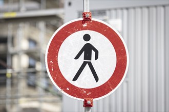 A prohibition sign with the pictogram for walking prohibited in front of a construction site in