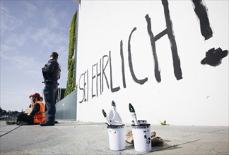 Demonstrators sit with signs in front of the Federal Chancellery, the demonstrators have written