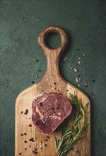 Fresh, raw rib eye steak, on a chopping board, top view, no people