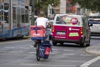 Flink delivery service courier cyclist and bottle delivery vehicle, in Düsseldorf, North