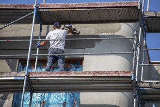 Painter painting the façade of a new apartment building