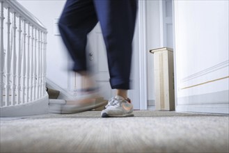 A woman leaves a parcel on her neighbour's doorstep in Berlin, 08.08.2024