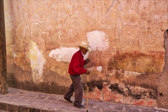 San Miguel de Allende, Mexico-3 December, 2018: Old man walking down the streets of San Miguel de