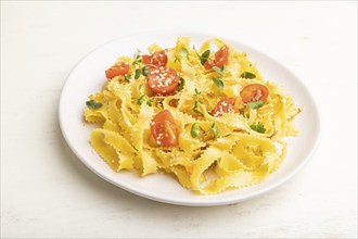 Reginelle semolina pasta with tomato, eggs, sesame and microgreen sprouts on a white wooden