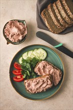 Liver meat pate spread on rye bread, breakfast, close-up, beige background. no people, selective