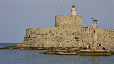 People strolling past a column near an old fortress by the sea, Fort of Saint Nikolaos, European