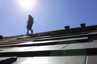 Silhouette of a roofer against the light