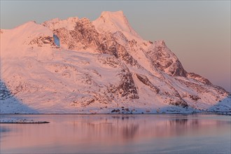 Snow-covered mountains reflected in the fjord at sunrise, winter, Reine, Moskenesoya, Lofoten,