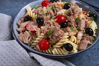 Fusilli pasta salad with canned tuna, cherry tomatoes and olives, parmesan, microgreens, homemade,