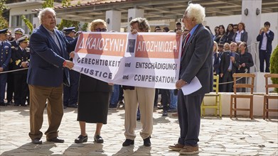 People holding banners with demands for justice and compensation, visit of Federal President