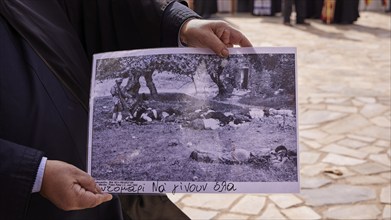 Close-up of a person holding a black and white photo in his hands, visit of the Federal President