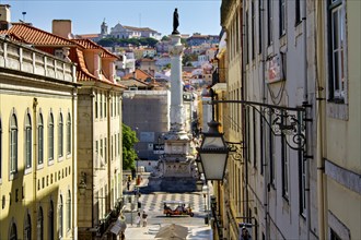 Sunny view down a Lisbon street leading to a statue with clear blue sky above, Lisbon