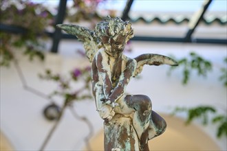 Close-up of an angel statue with weathered patina sitting on a pedestal, thermal springs, thermal