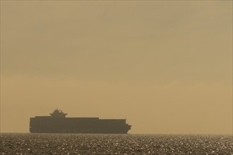 Container ship on the sea at sunrise heading to the port of Felixstowe, Suffolk, England, United