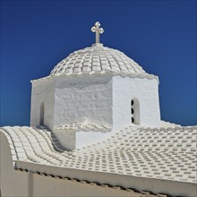 Cross-domed church Diasososuan, detailed view of a white church with dome under a bright blue sky,