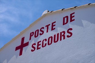 Rescue post building with inscription in red colour against a clear blue sky,