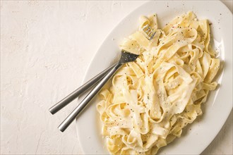 Fettuccine, tagliatelle, in creamy garlic sauce, Italian traditional cuisine, pasta carbonaro