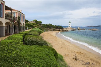 Lighthouse with beach and colourful houses, Spiaggia Porto Faro, Faro di Punta Palau, Palau, Costa