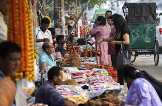 People buy Diya oil lamps and other decorative items at a market on the eve of Diwali, the Hindu