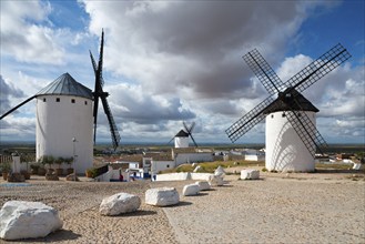 Three windmills in a village under a cloudy sky, Campo de Criptana, Ciudad Real province,