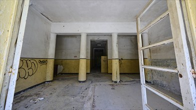 Abandoned interior with graffiti, pillars and bare walls in a desolate state, Lost Place, Former