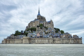 View of Mont Saint-Michel, a historic island with a monastery in a coastal landscape surrounded by